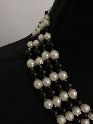 Sale Photo Thumbnail #69: A classic vintage multi-strand choker necklace featuring alternating rows of faux cream pearls with metal bead caps and polished black accent beads. Gold-tone chain extension and multi-strand spacer bars allow for adjustable sizing. Features nice luster a