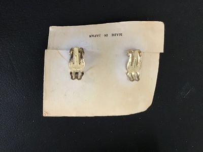 Sale Photo Thumbnail #73: Pair of vintage cluster clip-on earrings featuring a mix of black and white faux pearls in gold-tone metal filigree settings. Mounted on original display card stamped 'MADE IN JAPAN'. Clips are intact and functional. Minor age-appropriate wear visible.