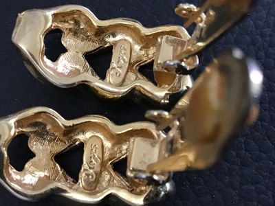 Sale Photo Thumbnail #80: A pair of vintage Keyes gold-tone clip-on earrings featuring a chunky twisted chain link design. Marked 'Keyes' on the reverse side of both earrings. Includes original comfort cushions on the clip mechanisms. Measure approximately 1 inch in length. In goo