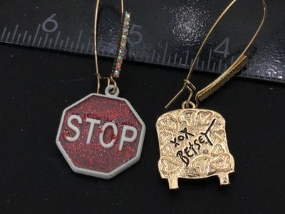 Sale Photo Thumbnail #131: Pair of Betsey Johnson mismatched drop/dangle wire earrings featuring a yellow enamel school bus with rhinestone accents on one side and a red glitter enamel stop sign on the other. Signed 'xox Betsey' on the back. Features gold-tone long French wire ear 