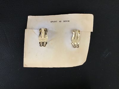 Sale Photo Thumbnail #74: Pair of vintage cluster clip-on earrings featuring a mix of black and white faux pearls in gold-tone metal filigree settings. Mounted on original display card stamped 'MADE IN JAPAN'. Clips are intact and functional. Minor age-appropriate wear visible.