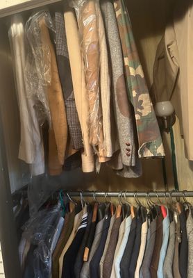 Sale Photo Thumbnail #11: A double-tiered closet filled with men's vintage blazers, suit jackets, and outerwear, including tweed, suede, and camouflage pieces.