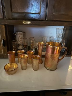 Sale Photo Thumbnail #58: Vintage marigold carnival glass water set featuring a textured pitcher, matching tumblers, a small bowl, and a flute vase, 