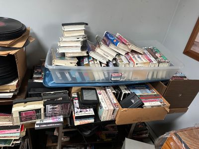 Sale Photo Thumbnail #65: Large collection of vintage media items, including VHS tapes, 8-track tapes, and vinyl records 