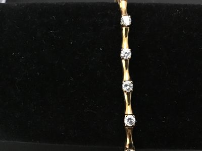 Sale Photo Thumbnail #90: Gold-tone over sterling silver (marked 925) tennis-style bracelet featuring bamboo-shaped links set with round clear cubic zirconia or glass stones. Box clasp with double safety latches. Measures approximately 7 inches in length. Pre-owned condition with 