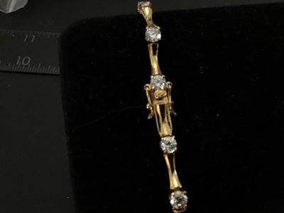 Sale Photo Thumbnail #94: Gold-tone over sterling silver (marked 925) tennis-style bracelet featuring bamboo-shaped links set with round clear cubic zirconia or glass stones. Box clasp with double safety latches. Measures approximately 7 inches in length. Pre-owned condition with 