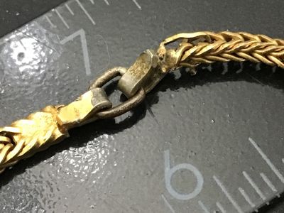 Sale Photo Thumbnail #133: Vintage gold-tone woven snake/fox tail chain bracelet featuring large faceted cobalt blue glass stones in crown prongs alternating with smooth black cabochon accent stones. Total length is approximately 7.5 inches as shown against the ruler. Metal shows l