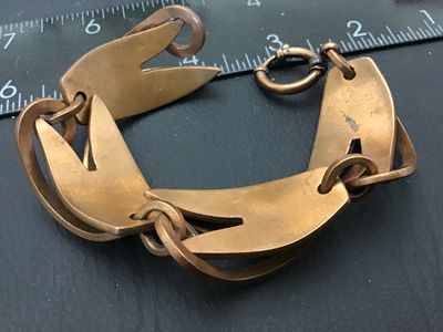 Sale Photo Thumbnail #119: A vintage Mid-Century Modern copper link bracelet featuring abstract black enamel panels decorated with spattered red and white design accents. The bracelet measures approximately 7.5 to 8 inches in length end-to-end, featuring sculpted copper overlay lin