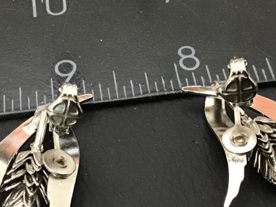 Sale Photo Thumbnail #63: Pair of vintage silver-tone clip-on earrings featuring a botanical design of wheat stalks and acorns. Clip-on backs are in good working condition. Each earring measures approximately 1.5 inches in length.