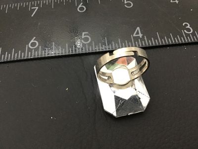 Sale Photo Thumbnail #182: Bold costume statement ring featuring a large emerald-cut iridescent rainbow crystal/glass stone on an adjustable silver-tone metal band. Shows light wear including small scratches to the top facet. Ring band is adjustable and shown measured around size 9