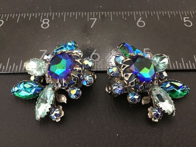 Sale Photo Thumbnail #143: Pair of vintage Judy Lee clip-on earrings featuring vibrant blue, green, and purple aurora borealis and marquise-cut rhinestones set in silver-tone metal floral settings. Marked Judy Lee on the clip backs. Each earring measures approximately 1.25 inches a