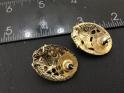 Sale Photo Thumbnail #80: Pair of gold-tone oval pierced stud earrings featuring an openwork lattice filigree design detailed with gold flowers and a central dimensional light pink porcelain rose with green leaves. Each earring measures approximately 1 inch in length. Complete wit