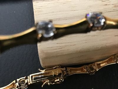 Sale Photo Thumbnail #95: Gold-tone over sterling silver (marked 925) tennis-style bracelet featuring bamboo-shaped links set with round clear cubic zirconia or glass stones. Box clasp with double safety latches. Measures approximately 7 inches in length. Pre-owned condition with 