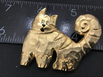 Sale Photo Thumbnail #81: Vintage gold-tone cat brooch by Ultra Craft featuring a hammered texture, curly tail, small rhinestone eyes, and a mouse accent near the bottom edge. Marked ULTRA CRAFT on the back. Measures approximately 2 inches wide by 2 inches tall. In good vintage co