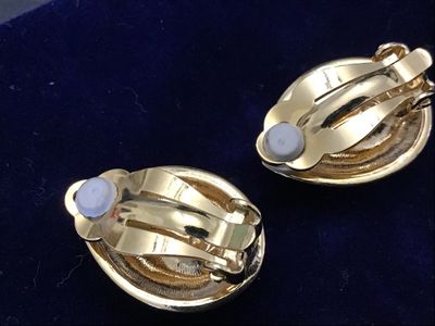 Sale Photo Thumbnail #111: Pair of vintage gold-tone clip-on earrings featuring large teardrop-cut dark blue crystal center stones surrounded by a halo of clear rhinestones. Features comfort pads on the clip backs. Measures approximately 3/4 inch in length. Items show light wear co