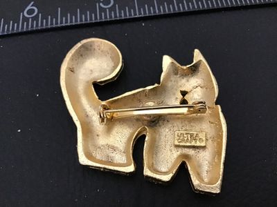 Sale Photo Thumbnail #84: Vintage gold-tone cat brooch by Ultra Craft featuring a hammered texture, curly tail, small rhinestone eyes, and a mouse accent near the bottom edge. Marked ULTRA CRAFT on the back. Measures approximately 2 inches wide by 2 inches tall. In good vintage co
