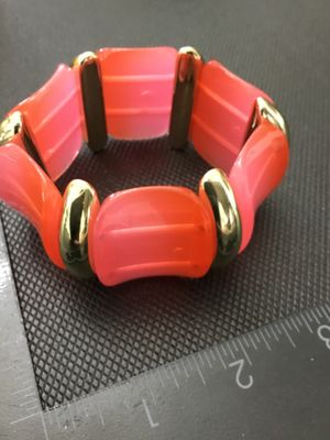 Sale Photo Thumbnail #243: Fashion stretch bracelet featuring vibrant pink and orange acrylic curved links separated by polished gold-tone spacer beads. Measures approximately 3 inches in outer diameter. In good pre-owned condition with light surface wear.