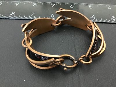 Sale Photo Thumbnail #117: A vintage Mid-Century Modern copper link bracelet featuring abstract black enamel panels decorated with spattered red and white design accents. The bracelet measures approximately 7.5 to 8 inches in length end-to-end, featuring sculpted copper overlay lin