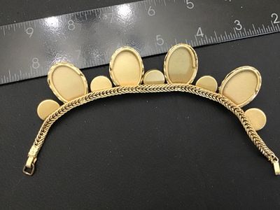 Sale Photo Thumbnail #132: Vintage gold-tone woven snake/fox tail chain bracelet featuring large faceted cobalt blue glass stones in crown prongs alternating with smooth black cabochon accent stones. Total length is approximately 7.5 inches as shown against the ruler. Metal shows l