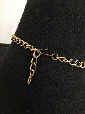 Sale Photo Thumbnail #3: A vintage Jose Barrera for Avon gold-tone collar statement necklace featuring intricate filigree scrollwork set with clear rhinestones. Includes an adjustable hook closure with an extender chain. Hallmarked 'Barrera for Avon' on the back. The necklace mea