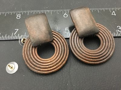Sale Photo Thumbnail #149: Pair of vintage carved wood geometric drop earrings featuring a rectangular top section attached to a concentric ring hoop. Includes plastic bullet clutch earring backs. Measure approximately 2.25 inches long. Pre-owned condition with natural wood grain v