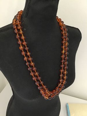 Sale Photo Thumbnail #34: Vintage multi-strand costume jewelry necklace featuring amber-tone round Lucite or resin beads with striped interior details. Includes an ornate gold-tone coiled wire centerpiece that doubles as a removable brooch/clasp piece with slide clip attachments. 