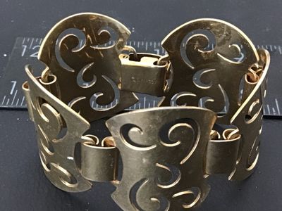 Sale Photo Thumbnail #49: Vintage Sarah Coventry gold-tone panel bracelet featuring filigree-style openwork scroll design panels connected by wide links. Marked '©SARAHCOV' on the fold-over clasp. Measures approximately 7 inches long. Shows minor surface wear and patina consisten
