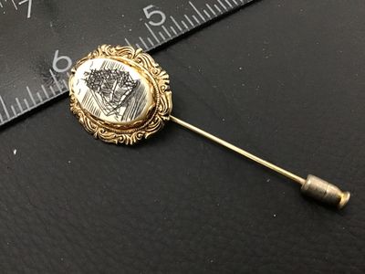 Sale Photo Thumbnail #21: Vintage stick pin featuring an oval cabochon with a scrimshaw-style illustration of a tall sailing ship surrounded by birds. Set in a gold-tone ornate filigree frame. Includes a protective pin guard end cap. Overall pin length measures approximately 2.5 i