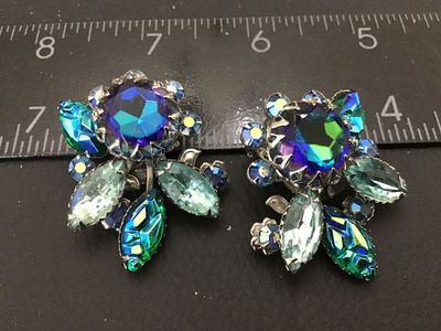 Sale Photo Thumbnail #142: Pair of vintage Judy Lee clip-on earrings featuring vibrant blue, green, and purple aurora borealis and marquise-cut rhinestones set in silver-tone metal floral settings. Marked Judy Lee on the clip backs. Each earring measures approximately 1.25 inches a