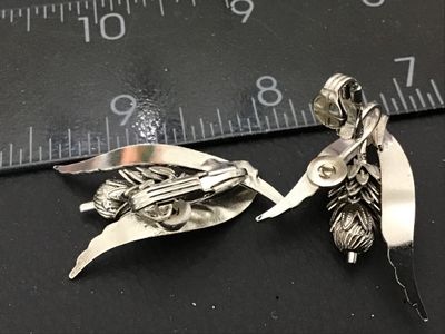 Sale Photo Thumbnail #62: Pair of vintage silver-tone clip-on earrings featuring a botanical design of wheat stalks and acorns. Clip-on backs are in good working condition. Each earring measures approximately 1.5 inches in length.