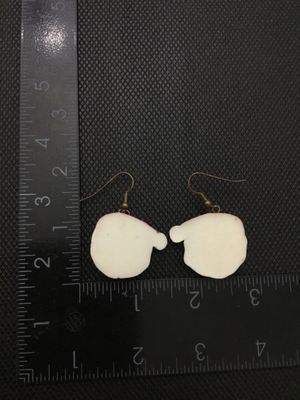 Sale Photo Thumbnail #238: A pair of festive Christmas Santa Claus face dangle earrings. Made of painted resin or plastic with brass-tone French wire ear hooks. The Santa face charms measure approximately 1 inch in width and height. Pre-owned in good condition with minor surface we