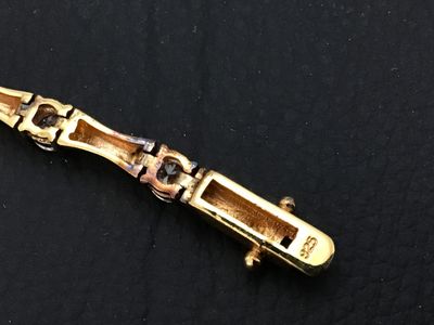 Sale Photo Thumbnail #93: Gold-tone over sterling silver (marked 925) tennis-style bracelet featuring bamboo-shaped links set with round clear cubic zirconia or glass stones. Box clasp with double safety latches. Measures approximately 7 inches in length. Pre-owned condition with 