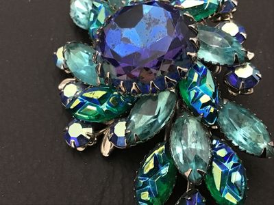Sale Photo Thumbnail #140: Vintage Judy Lee costume jewelry brooch featuring vibrant blue, aqua, and green aurora borealis marquis cut and round faceted glass rhinestones prong-set in silver-tone metal. Measures approximately 3 inches wide. Features a filigree back setting with sta