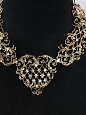 Sale Photo Thumbnail #2: A vintage Jose Barrera for Avon gold-tone collar statement necklace featuring intricate filigree scrollwork set with clear rhinestones. Includes an adjustable hook closure with an extender chain. Hallmarked 'Barrera for Avon' on the back. The necklace mea
