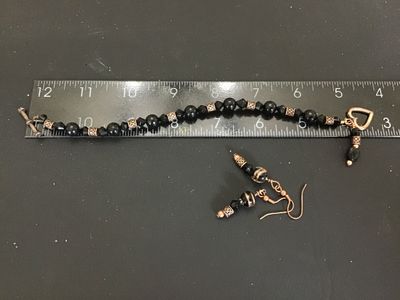Sale Photo Thumbnail #55: Matching costume jewelry set including a beaded bracelet and pair of dangle hook earrings. Features black round and faceted glass beads, copper-tone filigree metal spacer beads, and a heart-shaped toggle clasp on the bracelet. Bracelet measures approximat