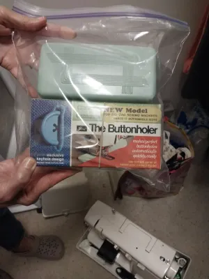 Sale Photo Thumbnail #93: Vintage Greist Buttonholer attachment set for zig-zag sewing machines, including the original box and mint green plastic storage case sealed in a plastic bag.
