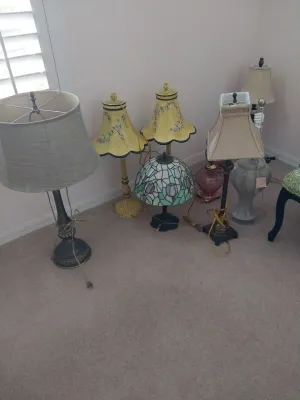 Sale Photo Thumbnail #57: Collection of assorted table lamps, including a floral stained-glass style lamp, a pair of painted yellow metal lamps, and various traditional fabric-shaded lamps.