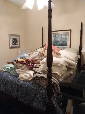 Sale Photo Thumbnail #68: Traditional four-poster wooden bed piled with a large assortment of linens, pillows, and comforters.