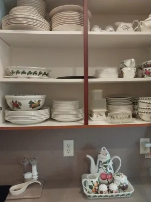 Sale Photo Thumbnail #26: Open kitchen cabinet filled with Portmeirion Botanic Garden and fruit-pattern ceramic dinnerware, alongside a matching coffee service set on the counter below.