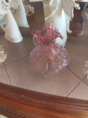 Sale Photo Thumbnail #46: Vintage pink glass vase with a ruffled rim, displayed on a mirror alongside white ceramic angel figurines.