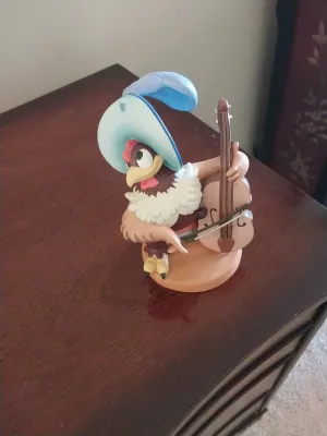 Sale Photo Thumbnail #104: Disney's Alan-a-Dale rooster figurine from Robin Hood playing the double bass, displayed on a wooden surface.