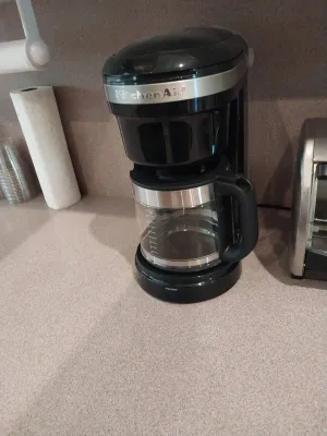 Sale Photo Thumbnail #32: Black and stainless steel KitchenAid 12-cup drip coffee maker with glass carafe.