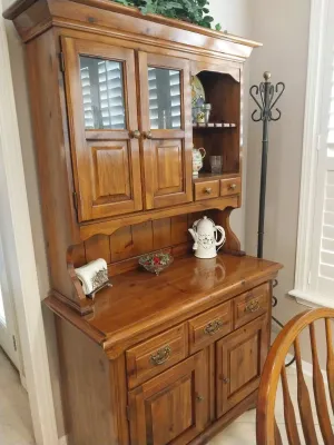 Sale Photo Thumbnail #24: Traditional pine china hutch featuring glass-pane upper cabinets, small drawers, and a lower buffet cabinet with brass hardware.