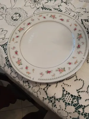 Sale Photo Thumbnail #35: Vintage white porcelain dinner plate featuring a delicate floral motif border and silver metallic rim, displayed on a lace tablecloth.