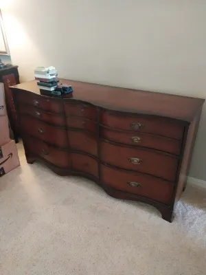 Sale Photo Thumbnail #2: Traditional serpentine front mahogany triple dresser featuring brass bail pull hardware and a rich cherry finish.