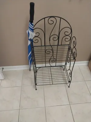 Sale Photo Thumbnail #98: Black wrought iron two-tiered scrollwork baker's rack paired with a blue and white striped umbrella.