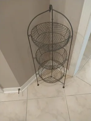 Sale Photo Thumbnail #28: Three-tiered rustic wire basket stand with an arched metal frame, ideal for storage or display.