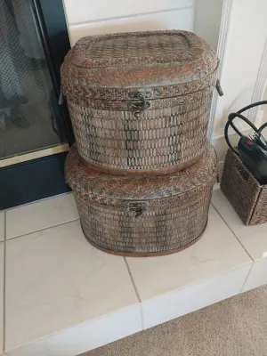 Sale Photo Thumbnail #12: Stacked pair of vintage oval woven wicker storage trunks featuring metal latch closures and leather-look trim.