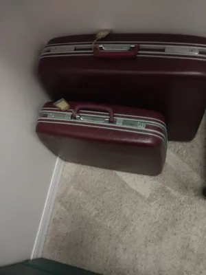 Sale Photo Thumbnail #91: Set of two vintage maroon hard-shell Samsonite suitcases with silver trim and handles, complete with luggage tags.