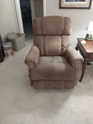 Sale Photo Thumbnail #6: Plush brown upholstered recliner chair, featuring a padded backrest and rolled armrests.